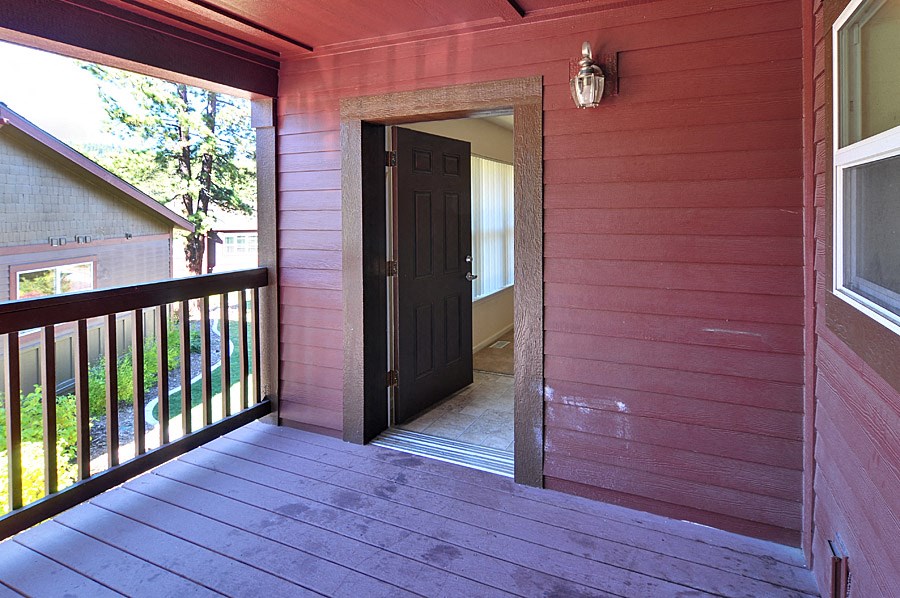 the front door of a red house with a porch