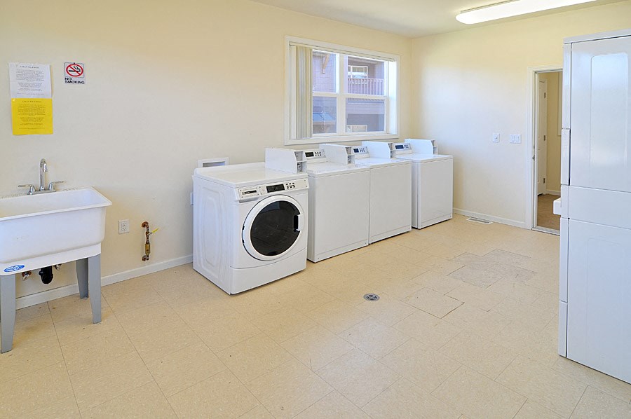 a washer and dryer room with four washing machines in a laundry room with