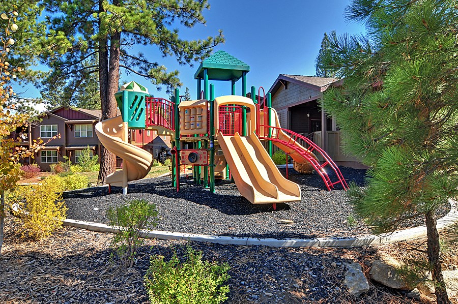 a playground with slides and other playground equipment in front of a building