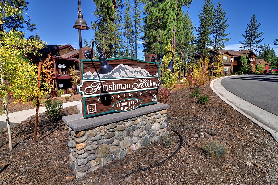 a sign at the side of a road in front of a building