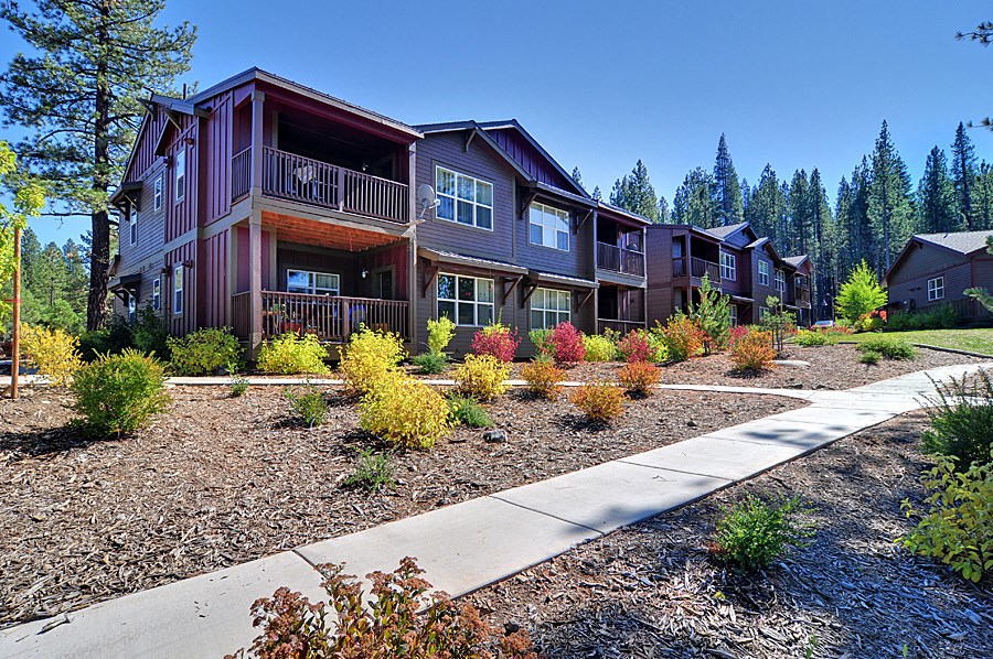 an apartment building with a sidewalk in front of it