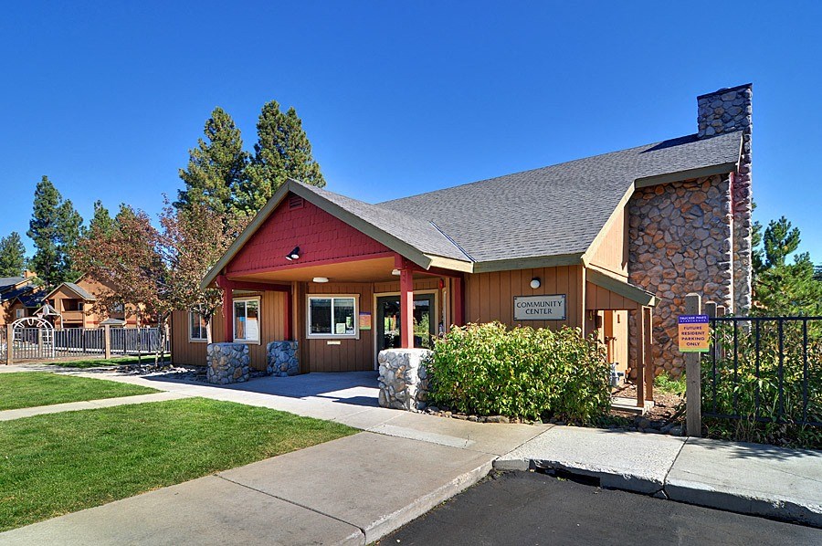 a building with a red roof and a stone chimney