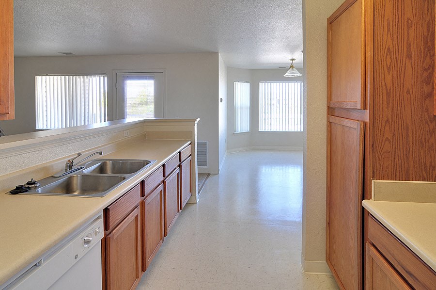 an empty kitchen with wooden cabinets and a sink
