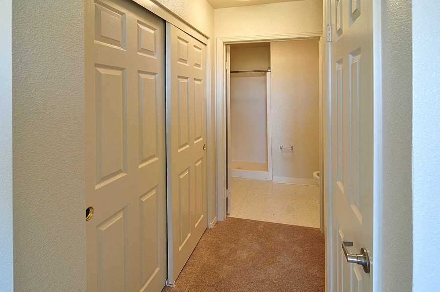 a hallway with two closets and a door to a closet