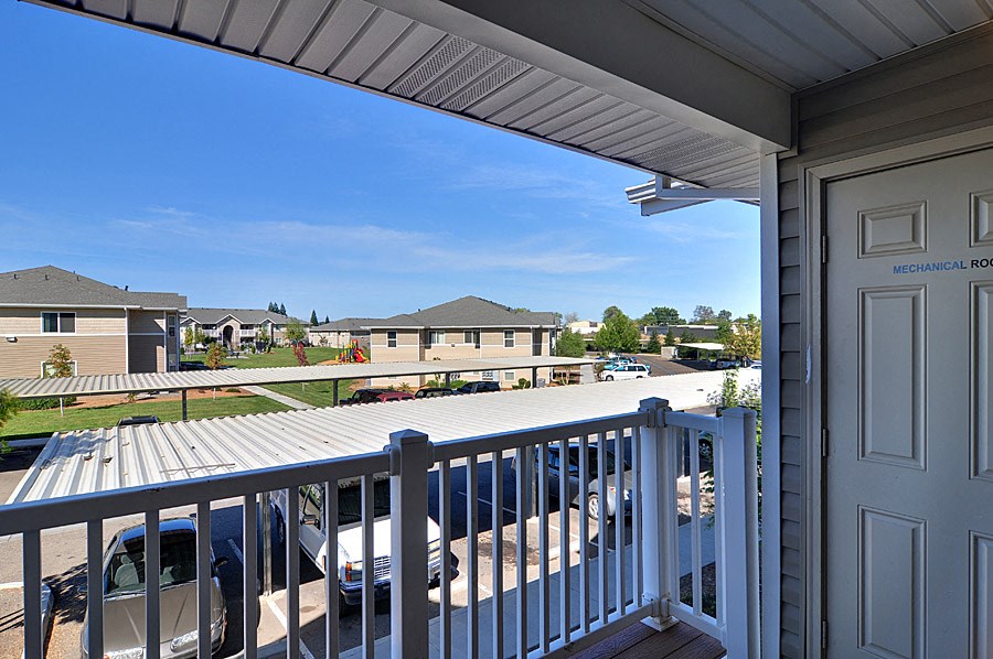 a balcony with a view of a parking lot and a house