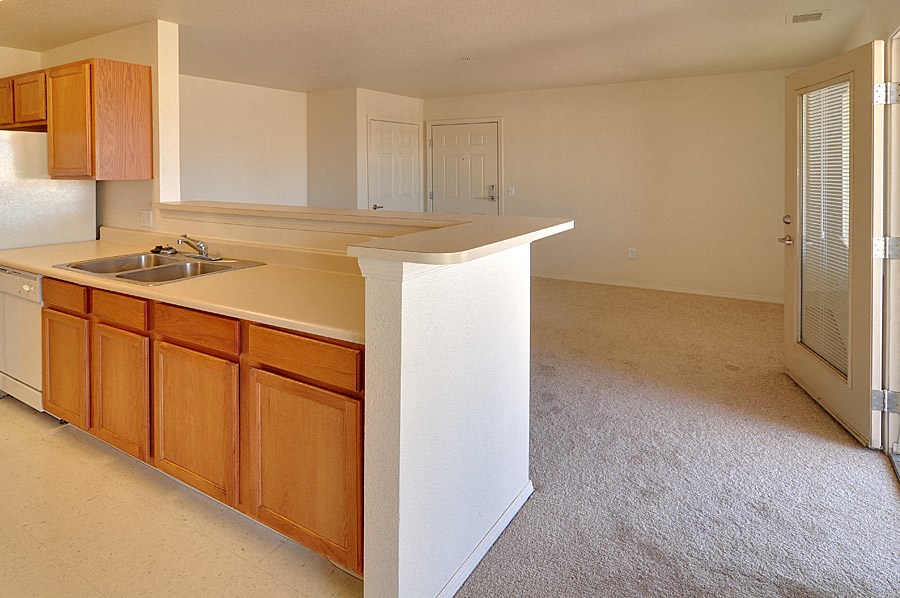 an empty kitchen with a counter top and a sink