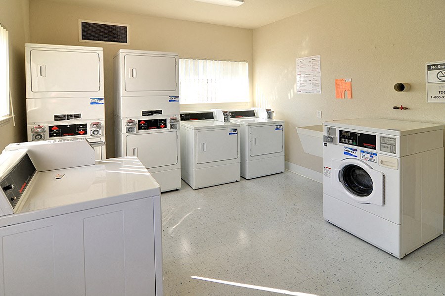 a laundry room filled with lots of white washes and dryers