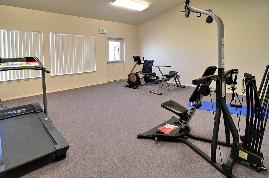 a gym with exercise equipment in an empty room