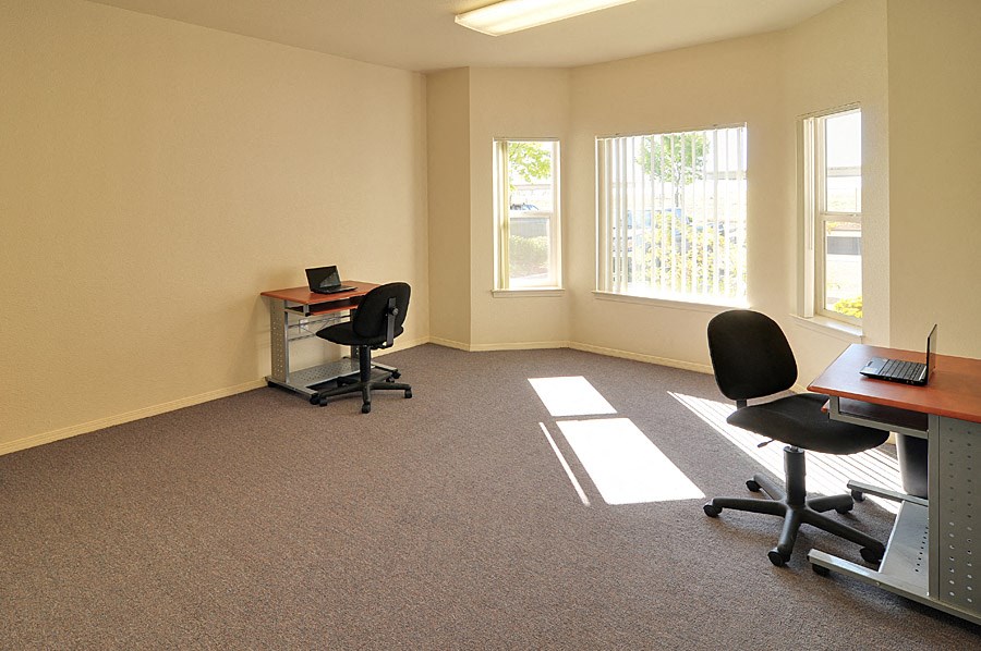 a room with a desk and chairs and a computer