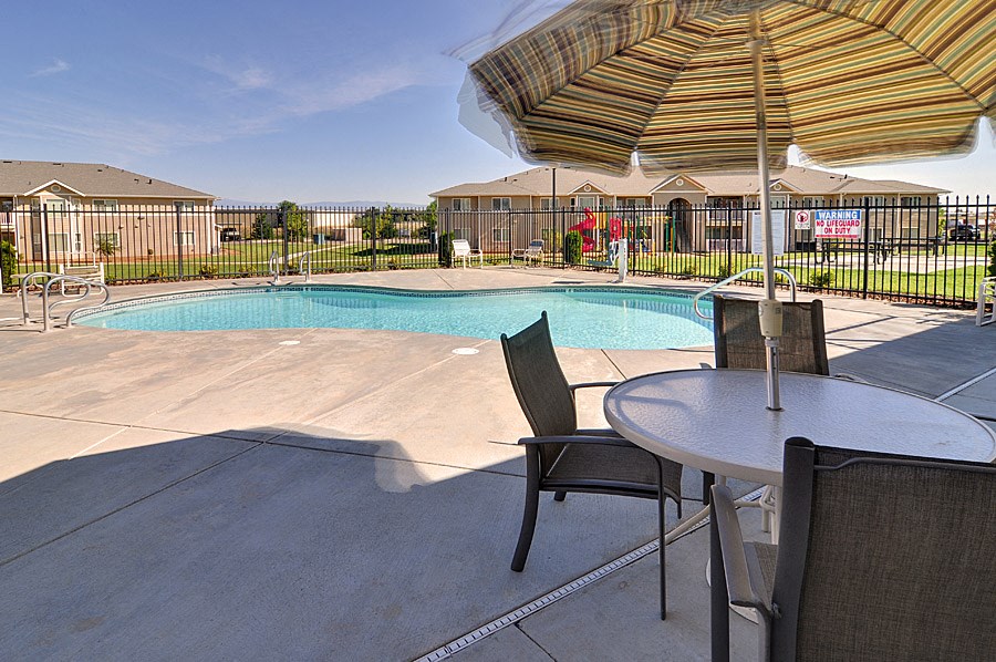 our apartments have a pool and patio with chairs and table