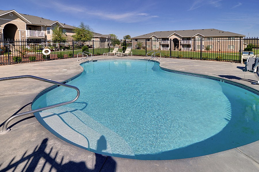 our apartments have a community pool with chairs and a fence