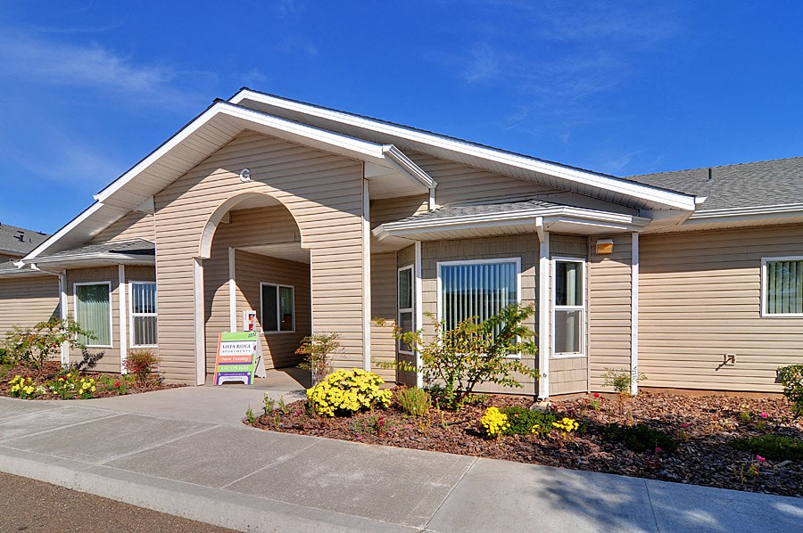 the exterior of a building with a sign in front of it