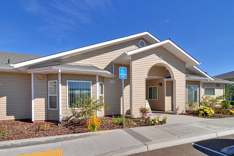 the front of a tan building with a blue sign on it