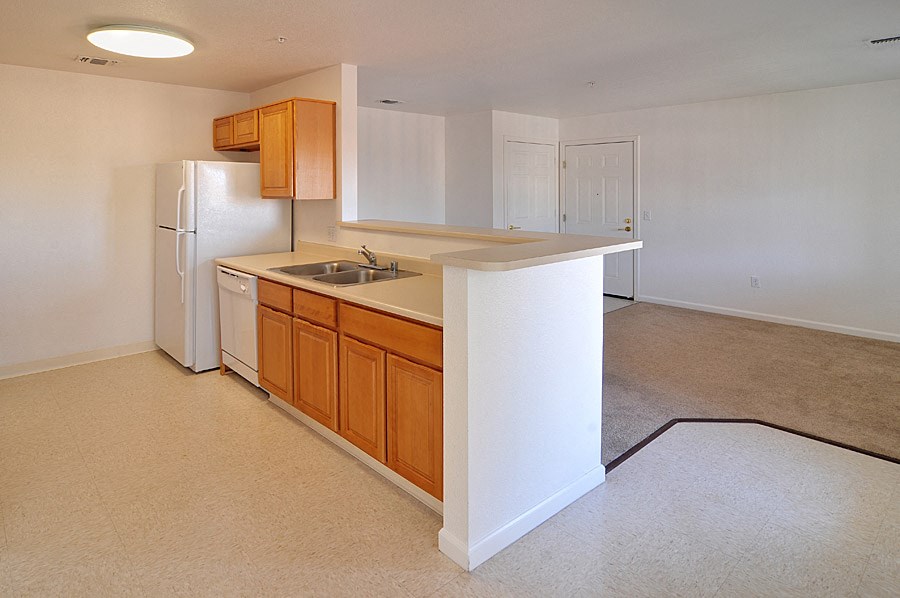 a kitchen with a white refrigerator freezer next to a dishwasher