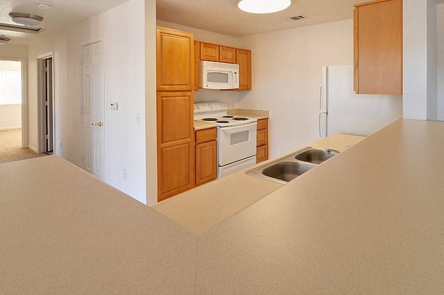 a kitchen with white appliances and wooden cabinets