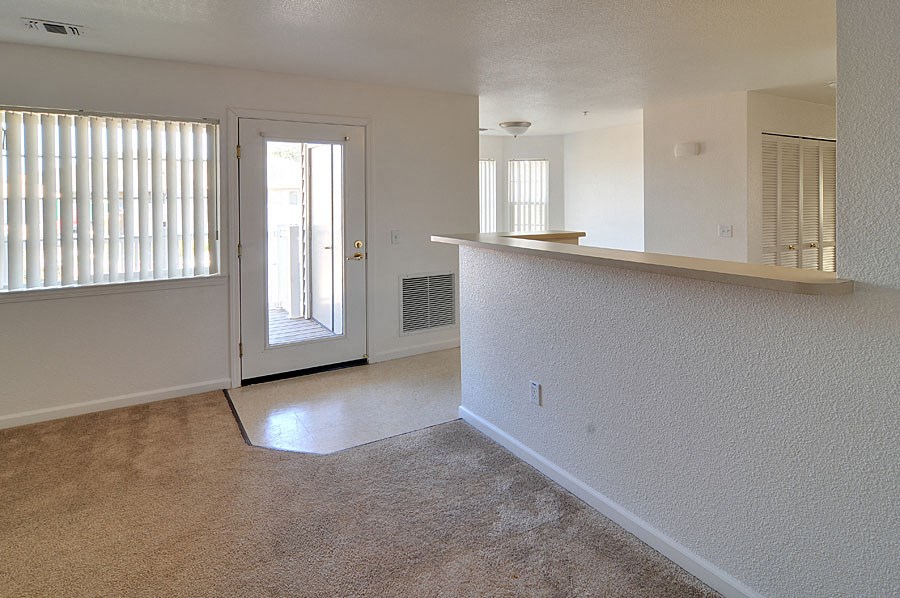 an empty living room with a door to a patio