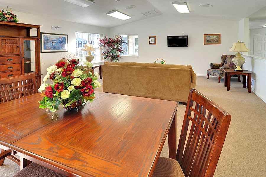 a living room and dining area with a wooden table and chairs