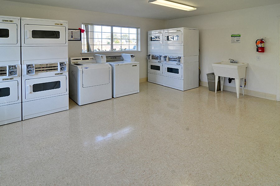 a laundry room with several stoves and a sink