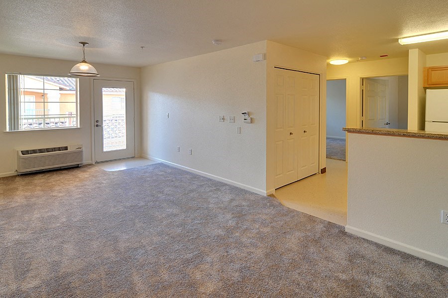 the living room and kitchen of an empty house with a white door