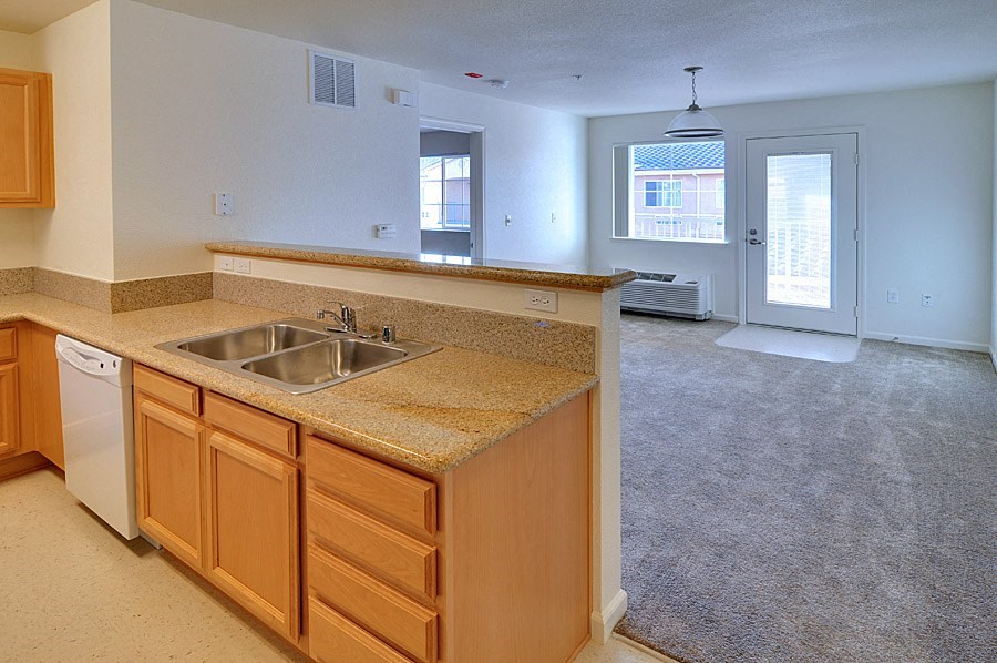 an empty kitchen and living room with a sink