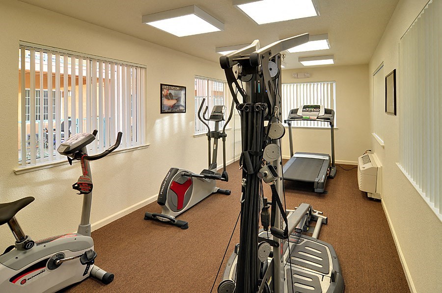 a gym with exercise equipment in a room with windows