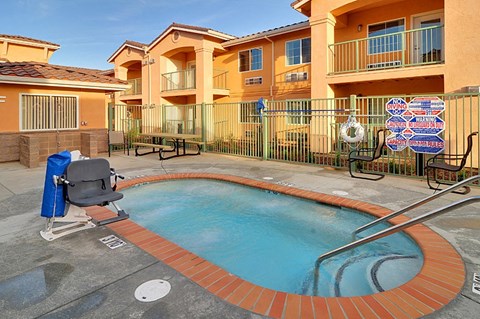 a swimming pool with a chair in front of an apartment building