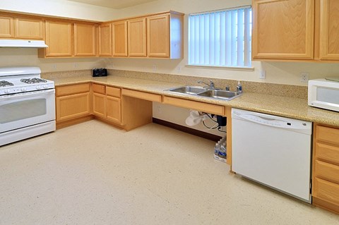 a kitchen with wooden cabinets and a white stove and sink