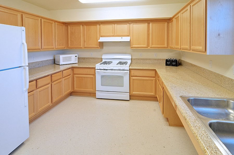 a kitchen with wooden cabinets and a stove and a sink