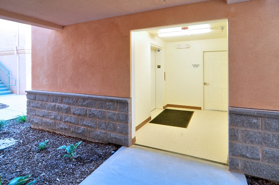 a hallway of a building with an open door and a carpet