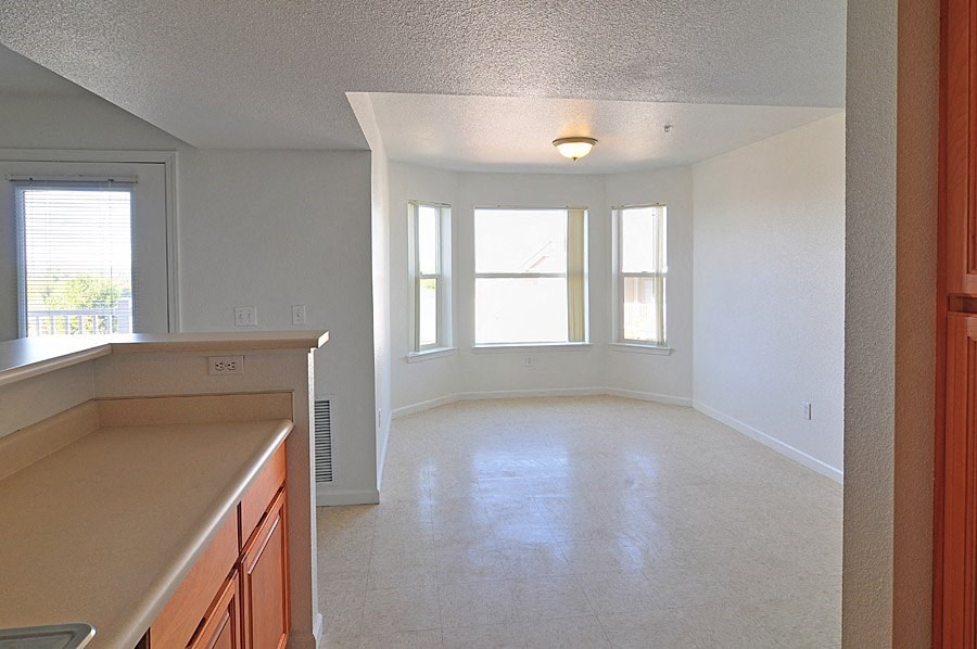 an empty kitchen and living room with a large window
