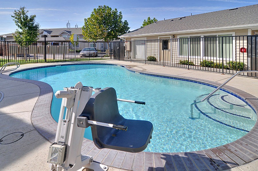 a swimming pool with a chair in front of a house