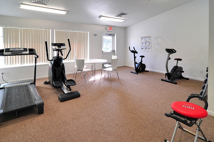 our gym has plenty of exercise equipment and a table and chairs