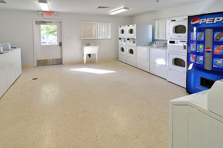 an empty laundry room with white appliances and a machine