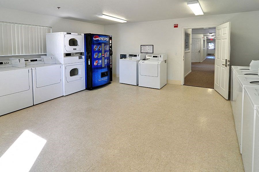 a room with a row of white washes and vending machines