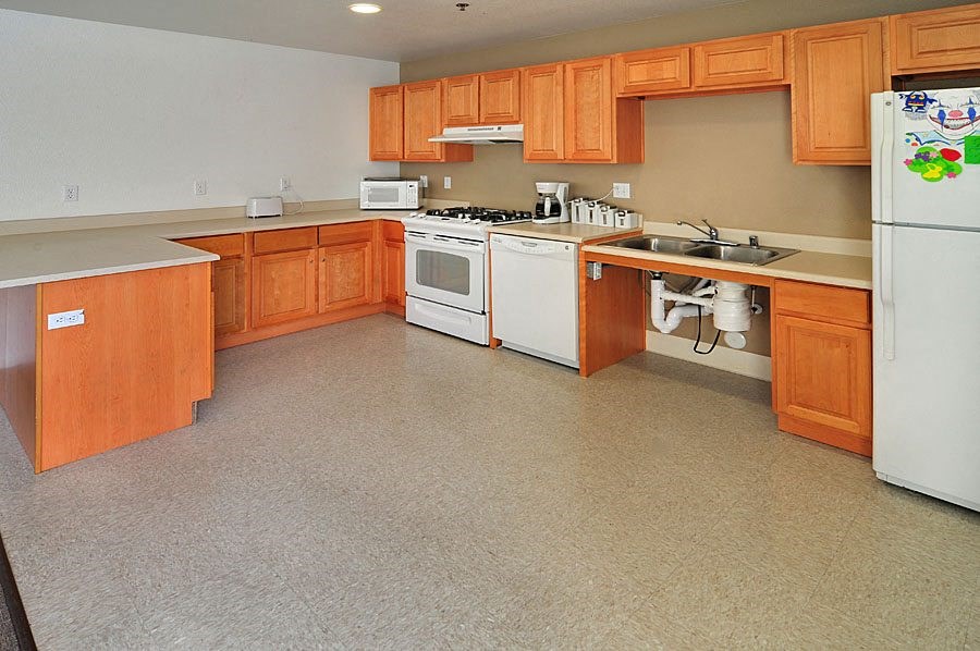a large kitchen with wooden cabinets and white appliances