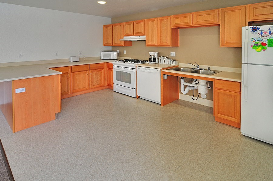 a kitchen with white appliances and wooden cabinets