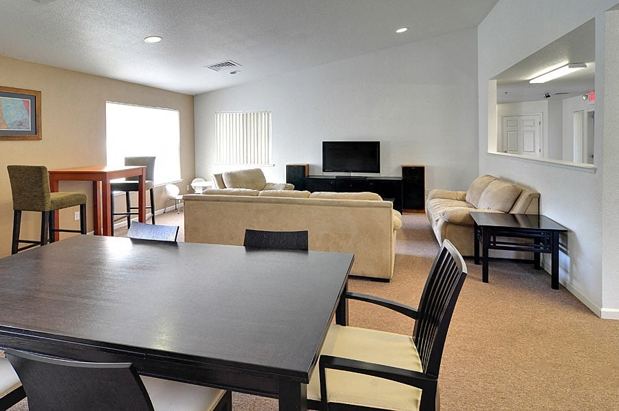 a living room and dining room with a table and chairs