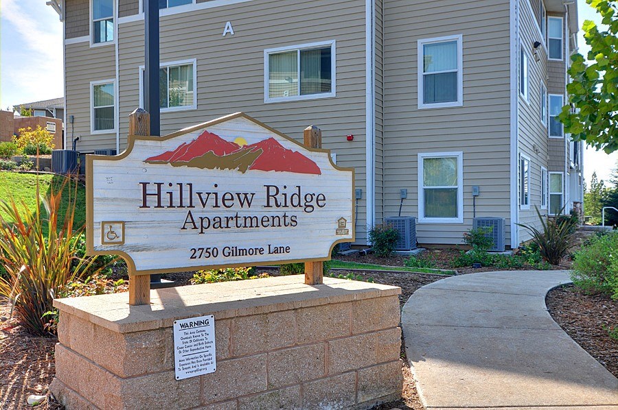 a sign for hill view apartments in front of a building