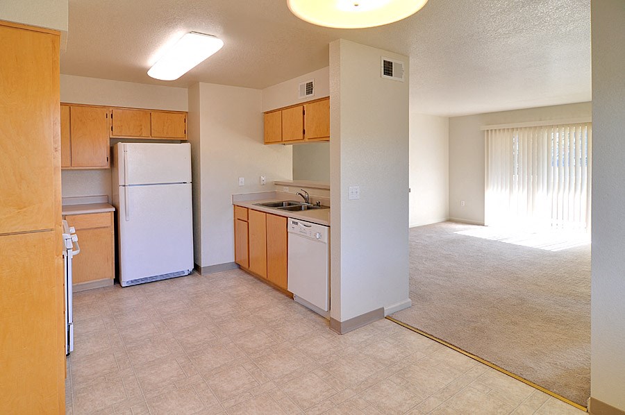 an empty kitchen with a refrigerator and a sink
