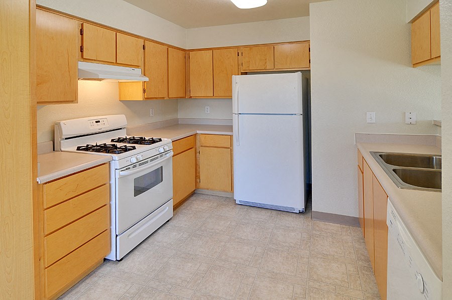 a kitchen with white appliances and wooden cabinets