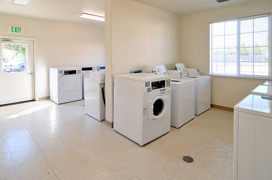 a washer and dryer room with a row of washing machines