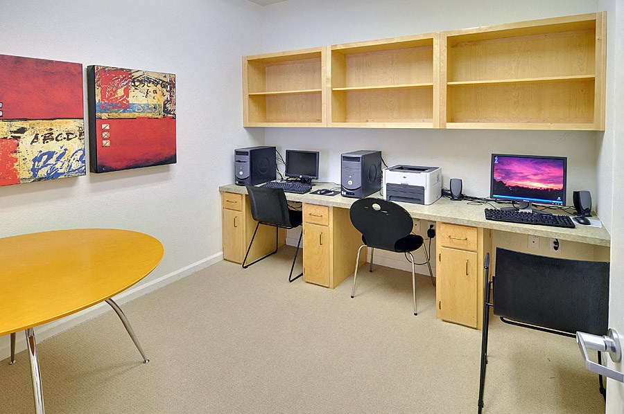 an office with a desk with a computer and a chair