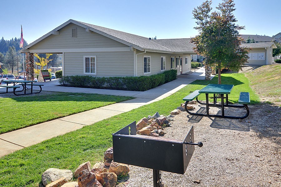 a picnic area with a grill and picnic table in front of a building