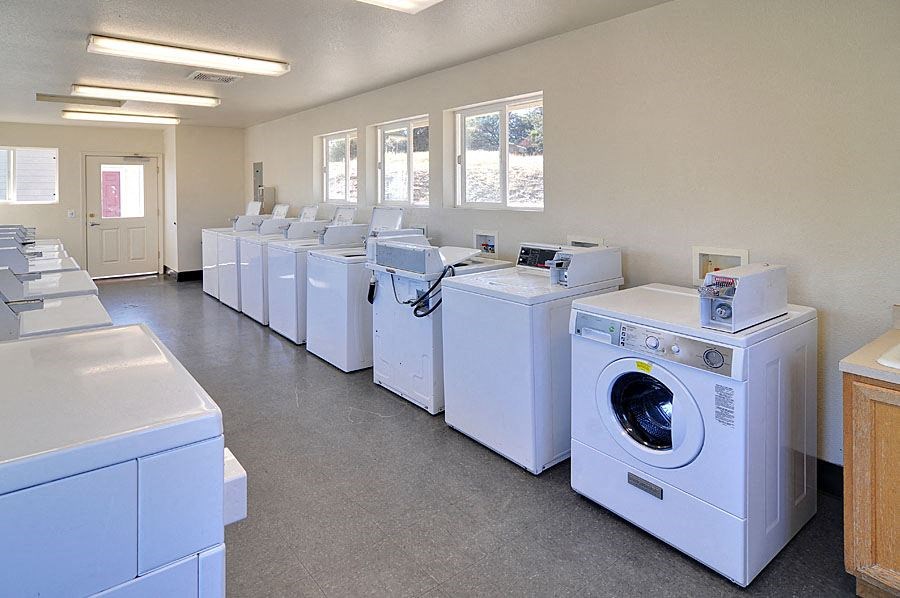 a laundromat with a row of white washing machines