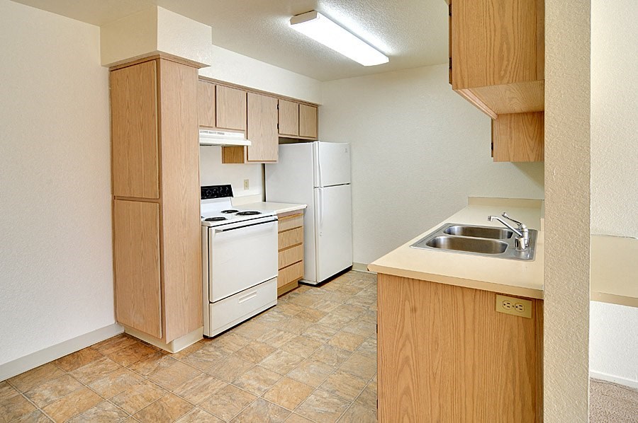 a kitchen with white appliances and wooden cabinets