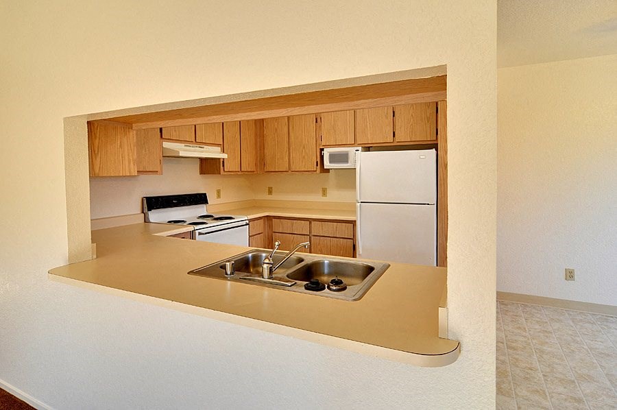 a kitchen with a sink stove refrigerator and microwave