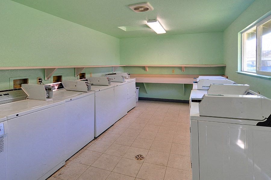 a room with a bunch of washers and dryers in it