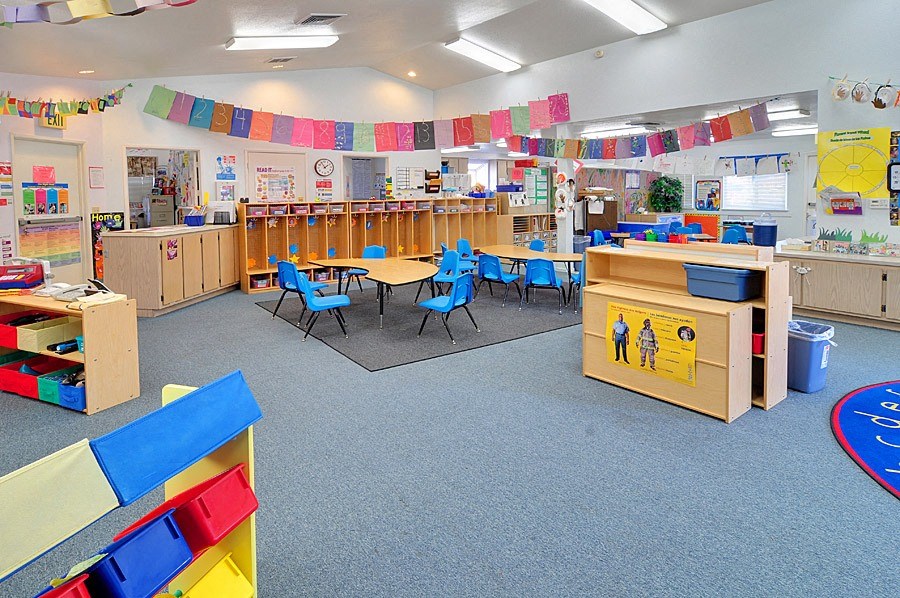 a classroom with tables and chairs in the middle of the room