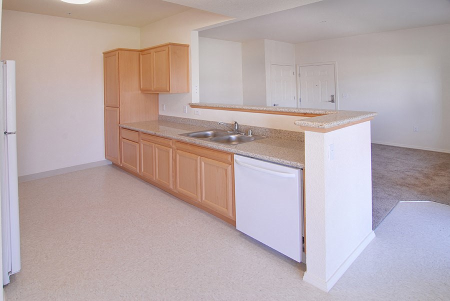 an empty kitchen with wooden cabinets and a sink