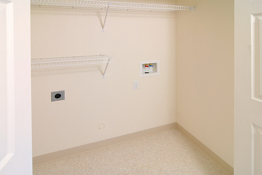 an empty room with a white wall and a shelf on the wall